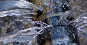 Large stream of water spraying from a one half inch leak