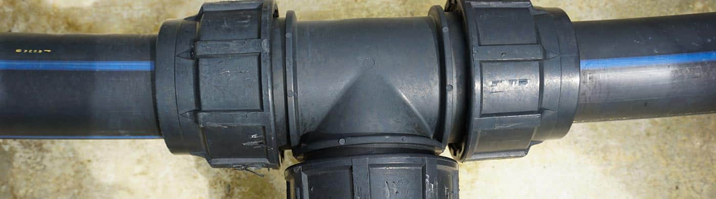 Black HDPE polyethylene pipe joined with a mechanical fitting