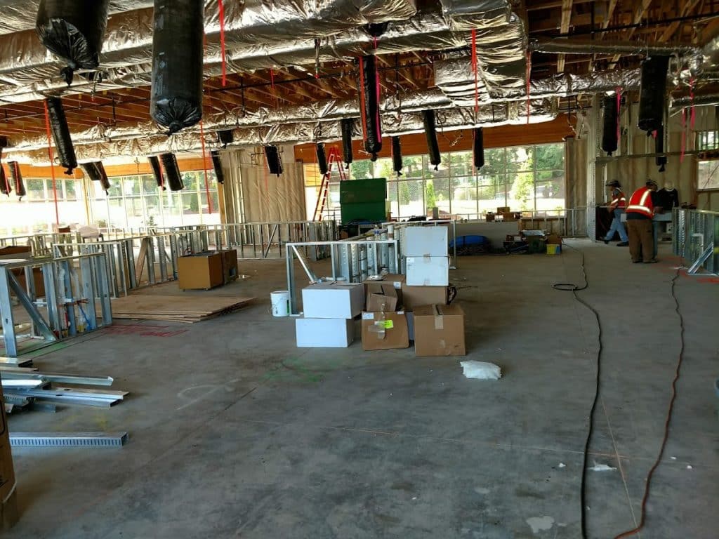 Building interior showing a large portion of the slab floor and stations with water and drain pipes installed