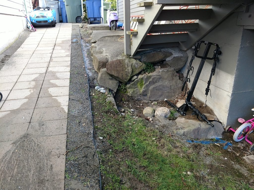 Hillside between homes with the located water pipe leak marked for repair