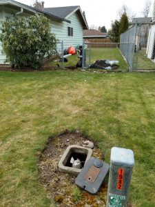 Technician working in a residential yard to locate an underground water leak