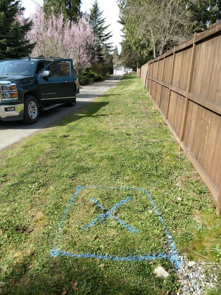 Located underground water pipe marking beside a residential driveway