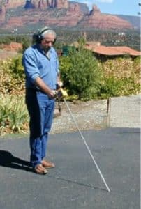 Technician using a ground microphone to investigate a possible water leak